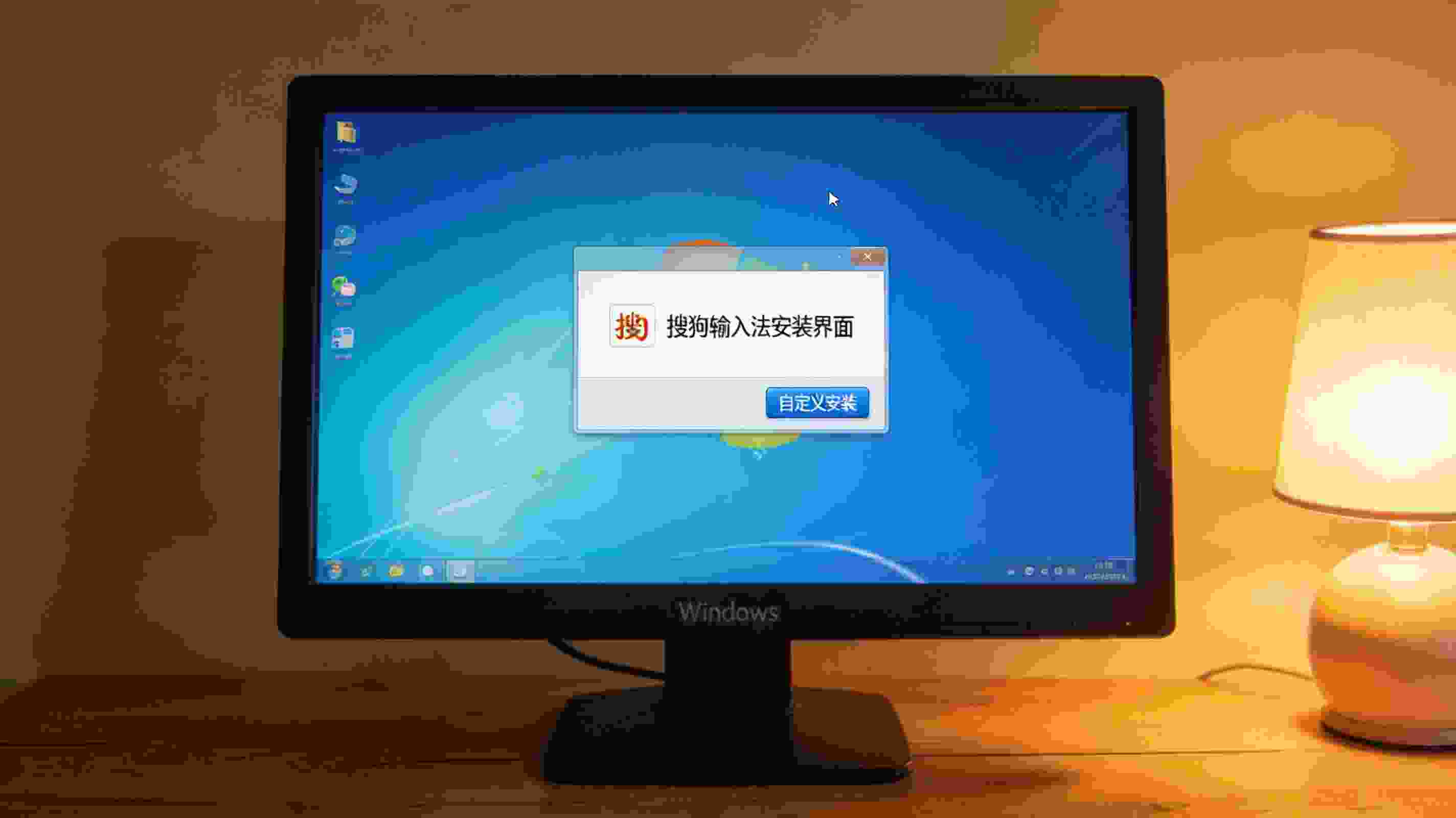 桌面的Windows系统电脑，屏幕显示搜狗拼音输入法安装界面，界面有自定义安装选项，桌角摆着台灯，台灯暖光