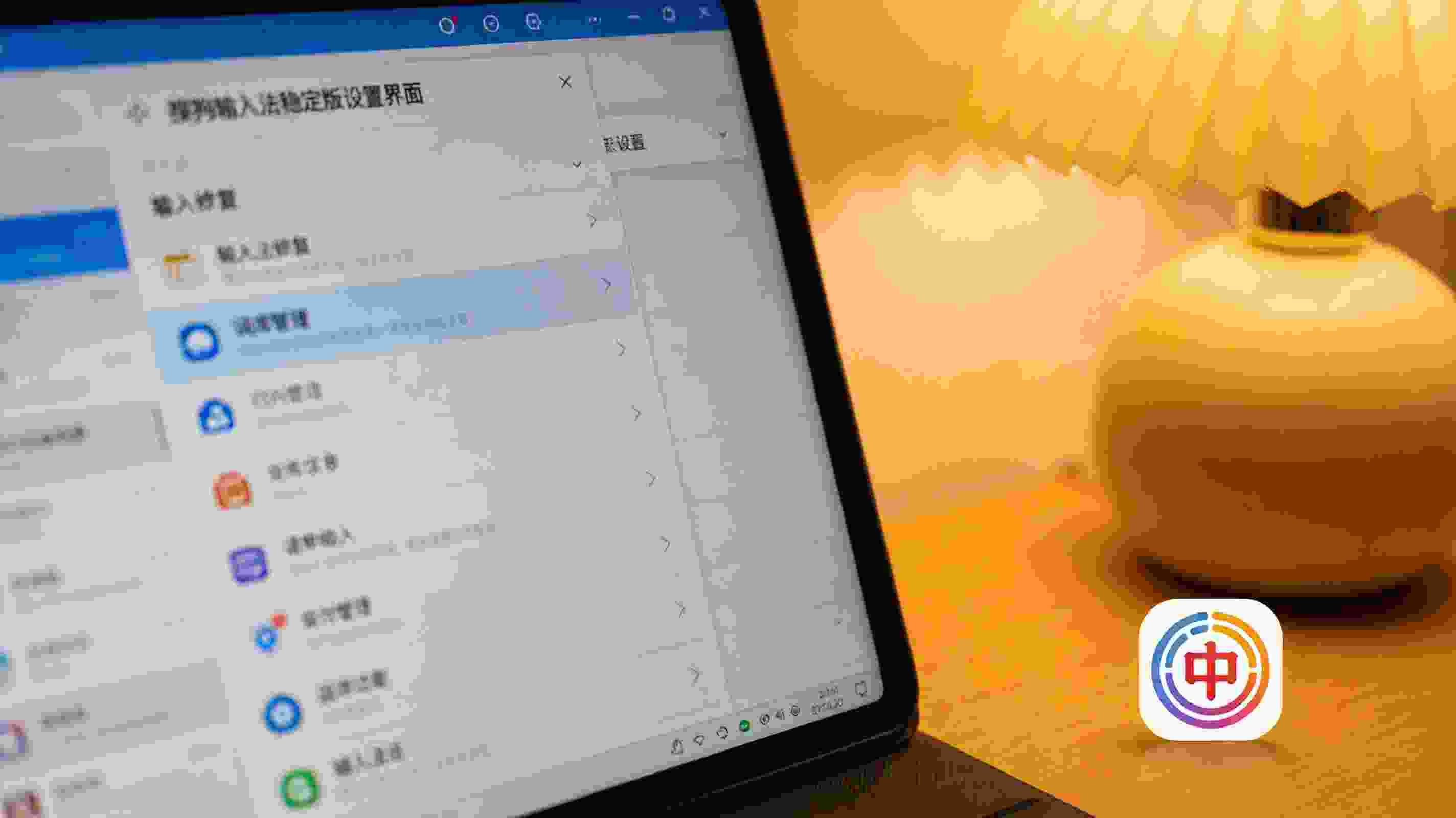 电脑屏幕显示搜狗拼音输入法稳定版设置界面，桌面右下角有输入法图标，台灯暖光