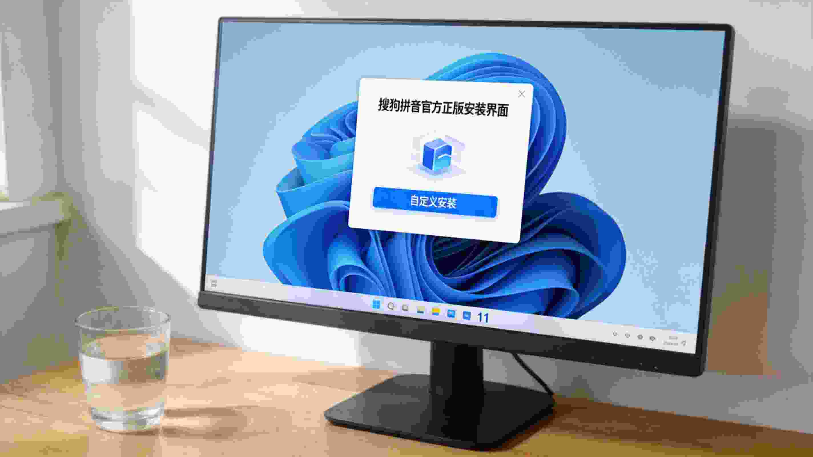 电脑桌的Windows11系统电脑，屏幕显示搜狗拼音官方正版安装界面，界面上有自定义安装选项，桌面放着半杯温水，室内自然光