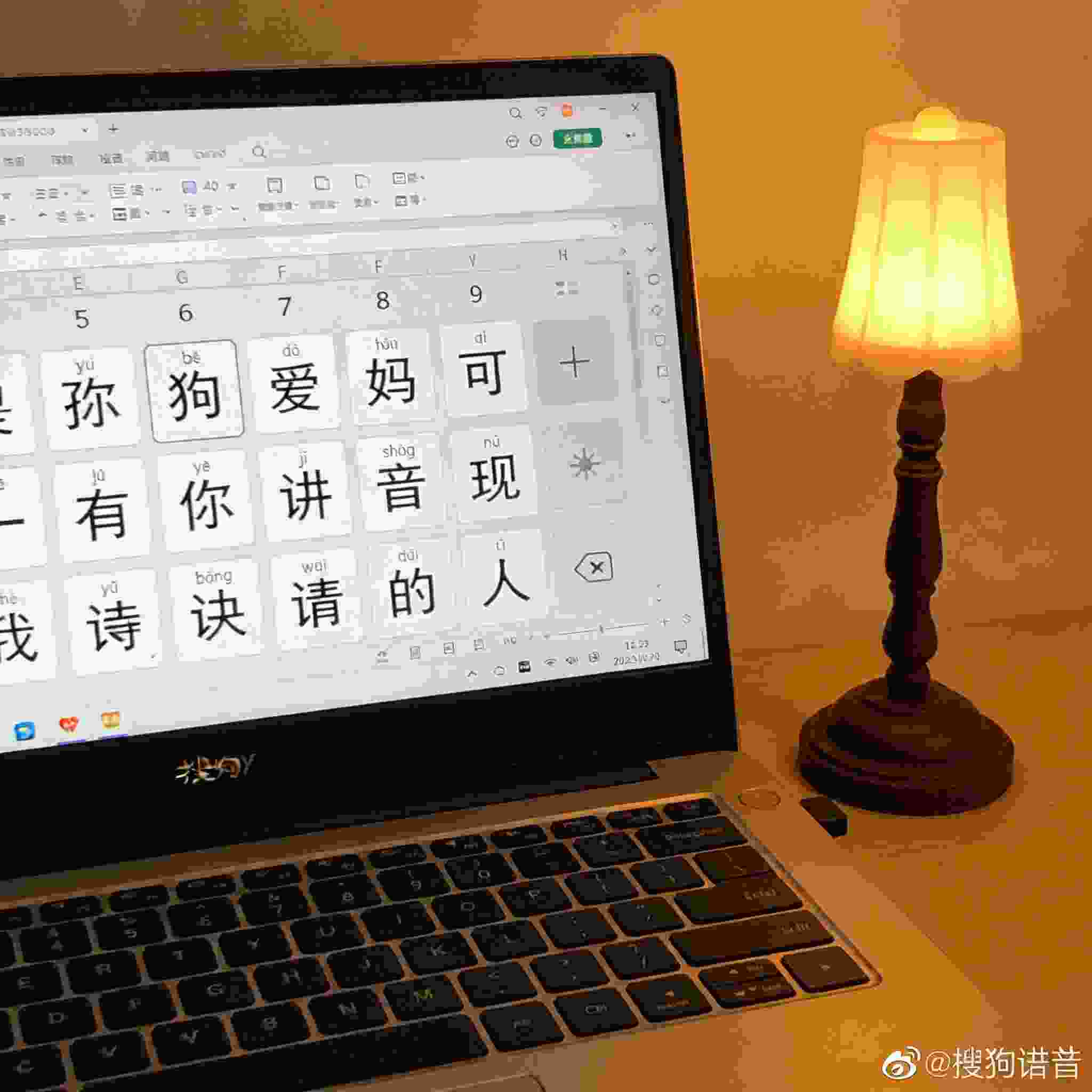 桌面的电脑屏幕显示搜狗拼音输入界面，候选词栏是大号字体，旁边摆着一盏小台灯，台灯暖光