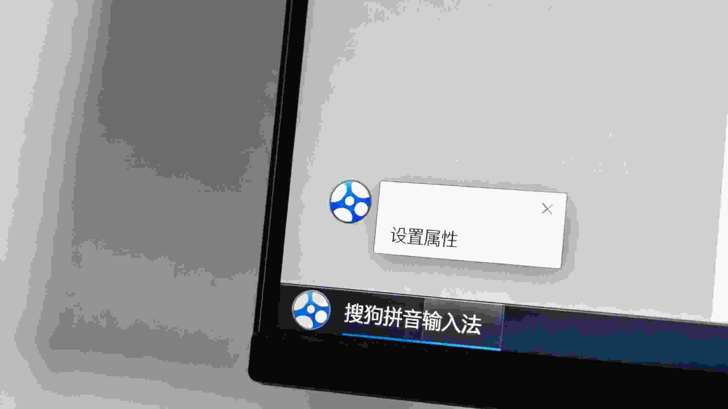 电脑桌面，屏幕显示任务栏上的搜狗拼音输入法图标，右键弹出的菜单里显示“设置属性”选项，室内自然光