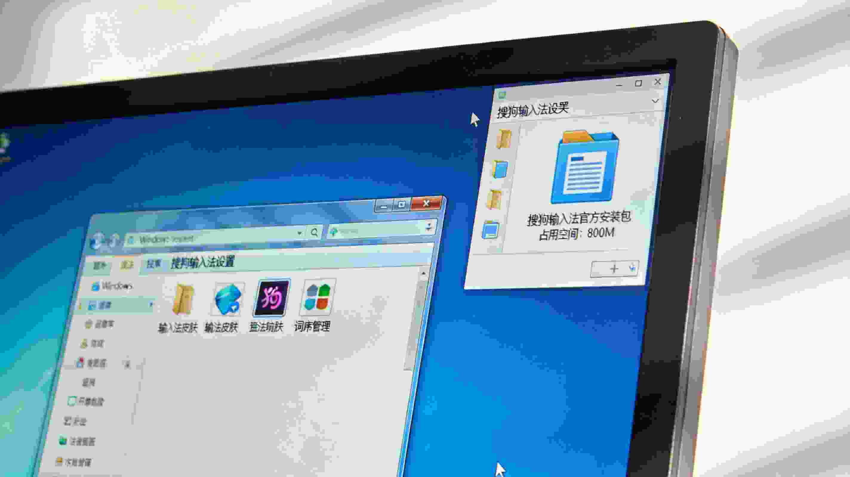 电脑桌面，屏幕显示Windows系统的搜狗拼音输入法设置界面，旁边的文件夹里显示官方安装包占用800M内存，室内自然光